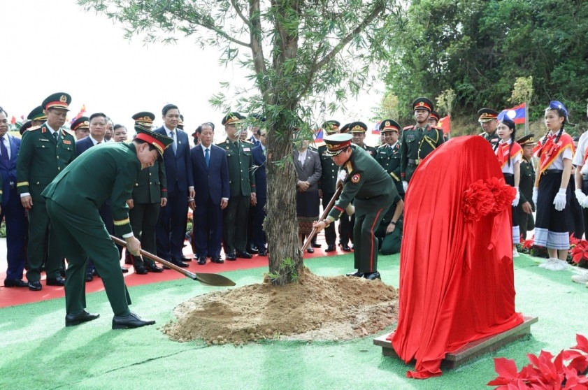The deputy PMs and defence ministers of Vietnam and Laos plant a commemorative tree.