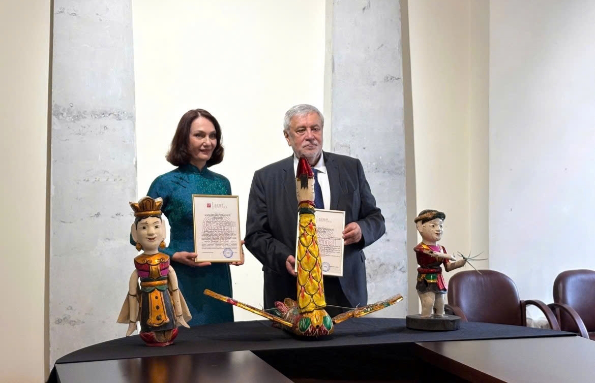 Elena Bezdetko (L), spouse of the Russian Ambassador to Vietnam, formally presents three Vietnamese water puppets to the representative of Russia’s State Museum of Oriental Art. (Photo: Sputnik)