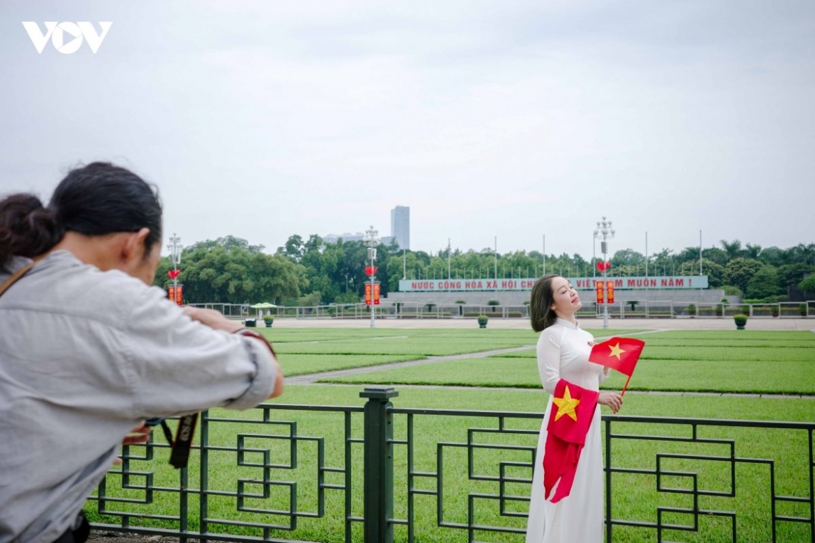 No elaborate pose is needed. Standing beside the national flag is enough to make the moment special.