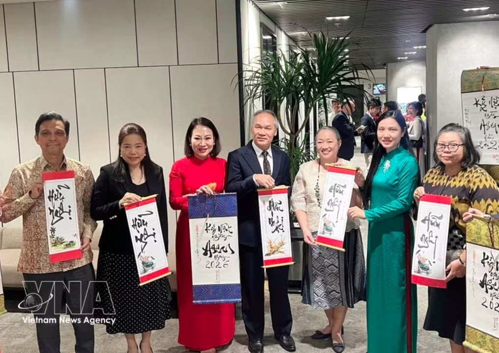 Consuls general of ASEAN countries in Ho Chi Minh City show calligraphy works presented to them at the gathering on August 7. (Photo: VNA)