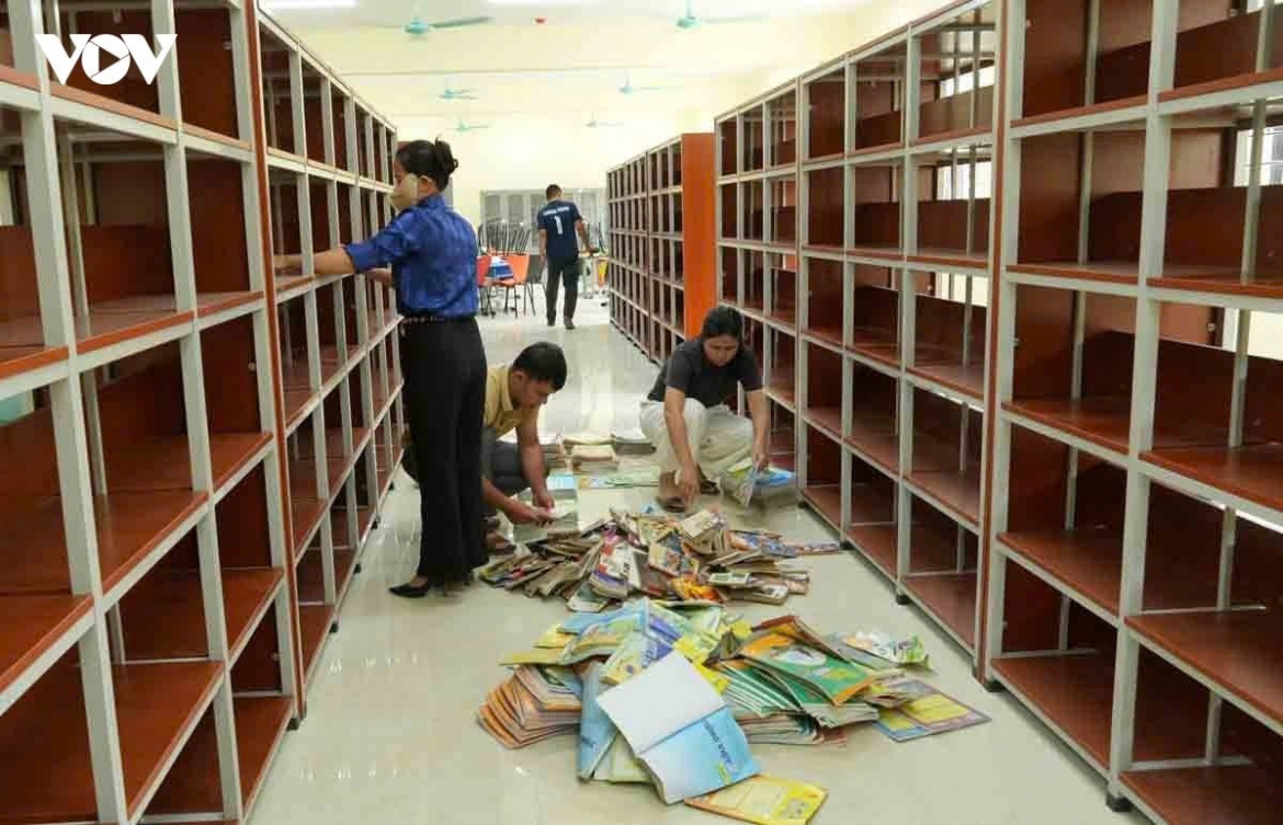 Near completion, the reading area will soon welcome students after lessons. Inside the library at Pa Tan School, teachers place new books neatly onto shelves..