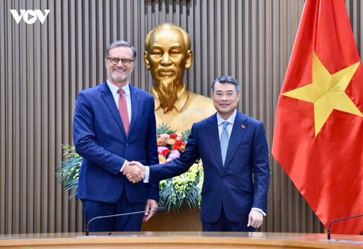 Vietnamese Prime Minister Le Minh Hung (R) and French Ambassador to Vietnam Olivier Brochet shake hands ahead of their meeting in Hanoi on August 26, 2026