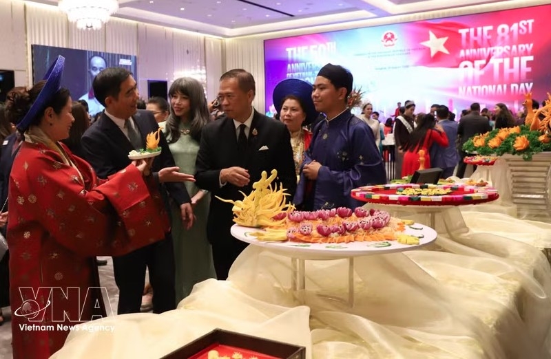 Ambassador Pham Viet Hung (second, left) introduces the unique "nem cong" (peacock spring rolls) of Hue royal cuisine to Thai Vice Minister of Foreign Affairs Vijavat Isarabhakdi (Photo: VNA)