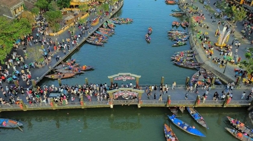Tourists stroll along both banks of the Hoai River in Hoi An.