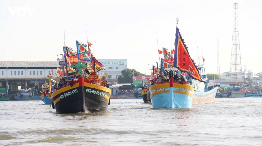 Ceremonial boats adorned with festival flags participates in the Leng Ong Sanh procession on the Ca Ty River in Phan Thiet Ward.
