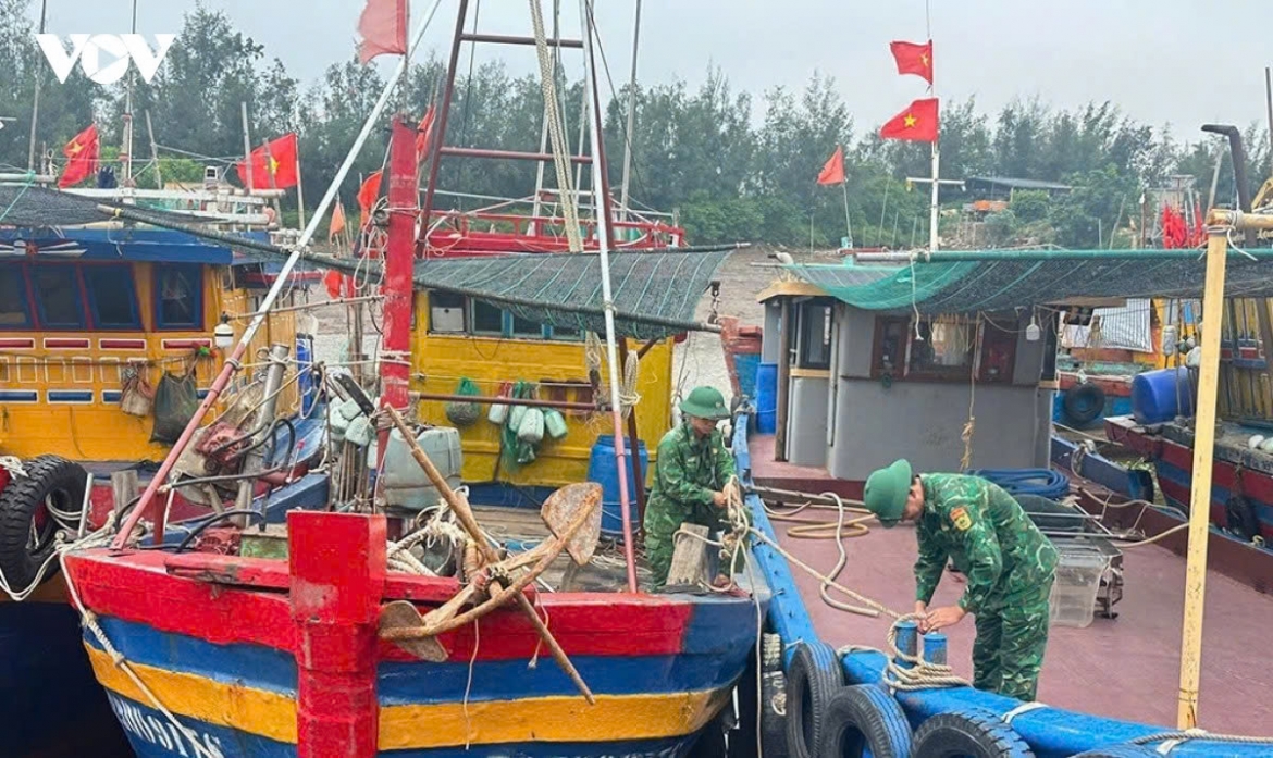 Cua Lan Border Guard soldiers help fishermen secure their boats at a storm shelter anchorage