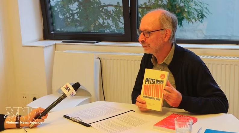 Bert De Belder, Head of the PTB’s Department of International Relations, introduces Peter Mertens’ book Mutiny: How Our World Is Tilting. (Photo: VNA)